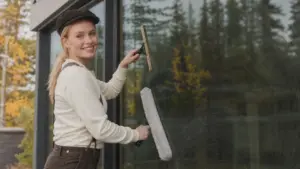 Ikkunanpesijä pesee suuren ikkunan suomalaisena syyspäivänä.